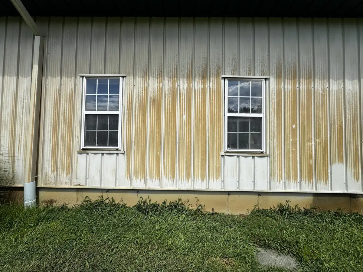 Metal building siding with heavy rust stains before cleaning by Skyline